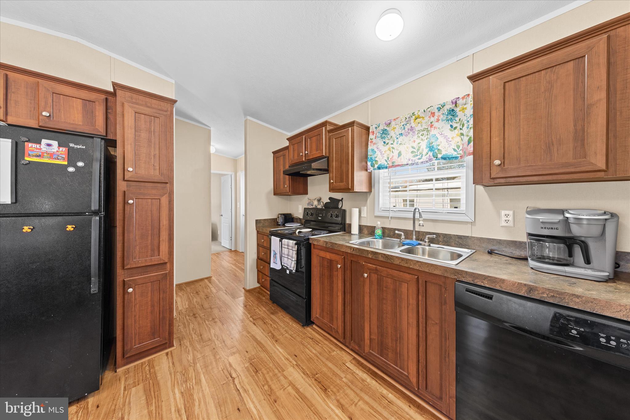 33461 Daisy Street Lewes, DE 19958 - Photo 19 of 42 a kitchen with granite countertop wooden cabinets stainless steel appliances a sink and a window