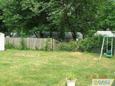 12 Bucknell Road Old Bridge, NJ 08859 - Photo 2 of 8 a backyard of a house with plants and large trees