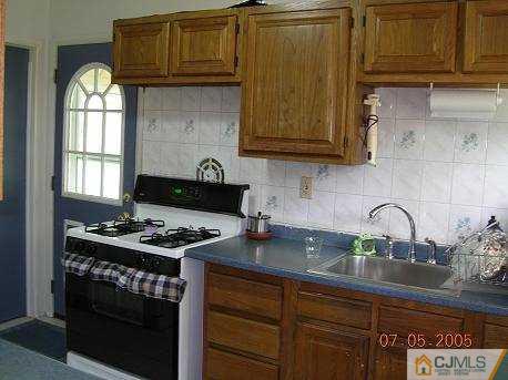 12 Bucknell Road Old Bridge, NJ 08859 - Photo 3 of 8 a kitchen with granite countertop a stove a sink dishwasher and cabinets with wooden floor