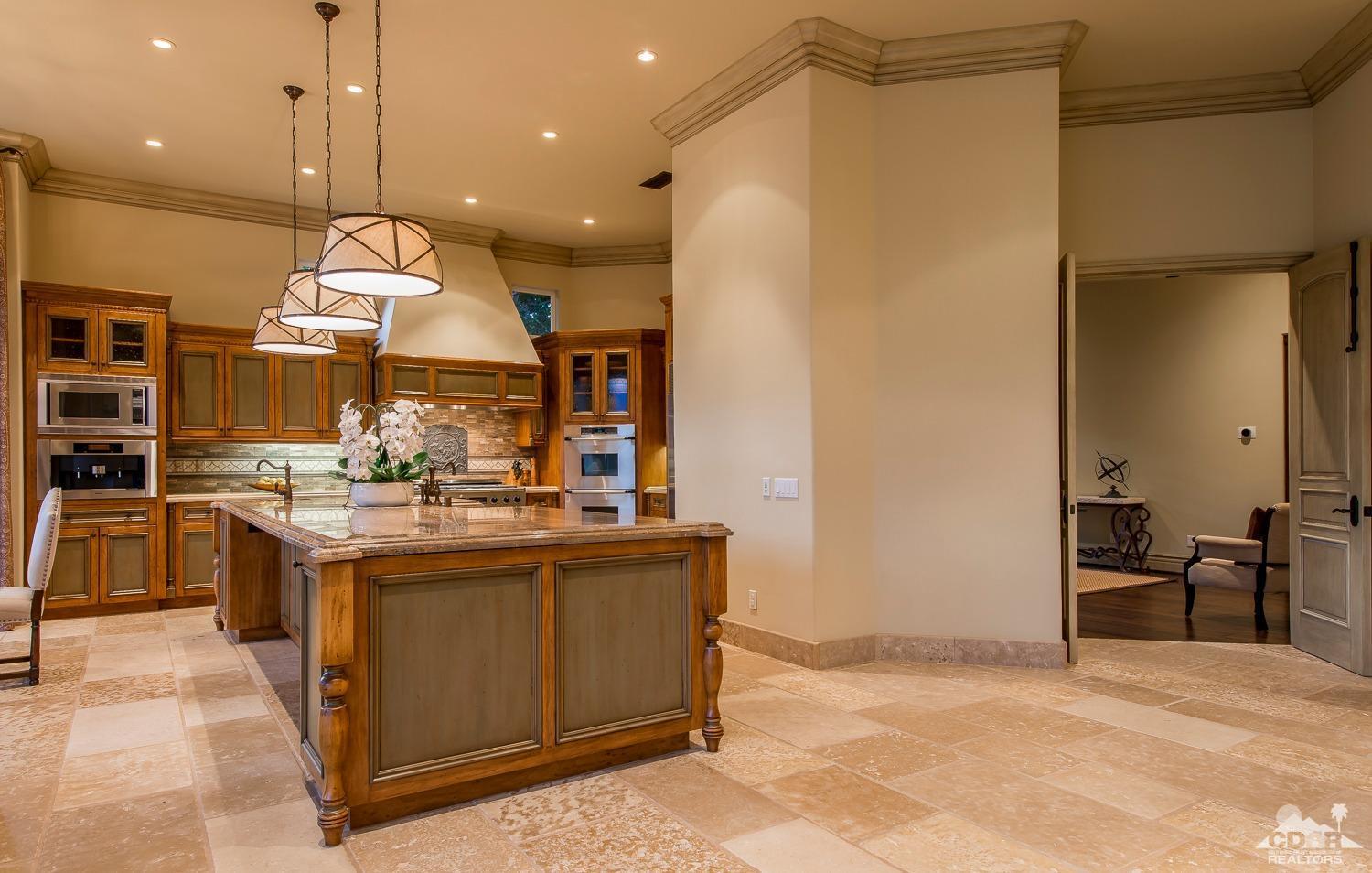 80515 Weiskopf La Quinta, CA 92253 - Photo 30 of 46 a kitchen with kitchen island a stove a counter top space and a view of living room