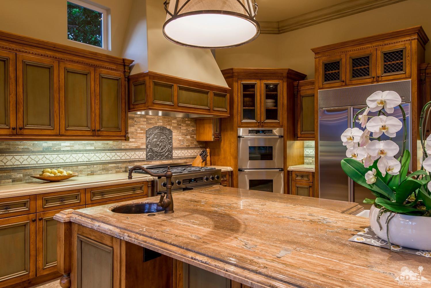 80515 Weiskopf La Quinta, CA 92253 - Photo 32 of 46 a kitchen with stainless steel appliances granite countertop a stove a sink and a microwave