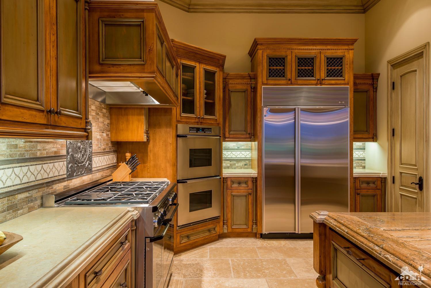 80515 Weiskopf La Quinta, CA 92253 - Photo 33 of 46 a kitchen with stainless steel appliances granite countertop a stove and a refrigerator