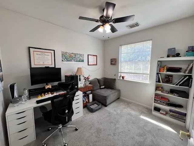 a view of a workspace with furniture and a window
