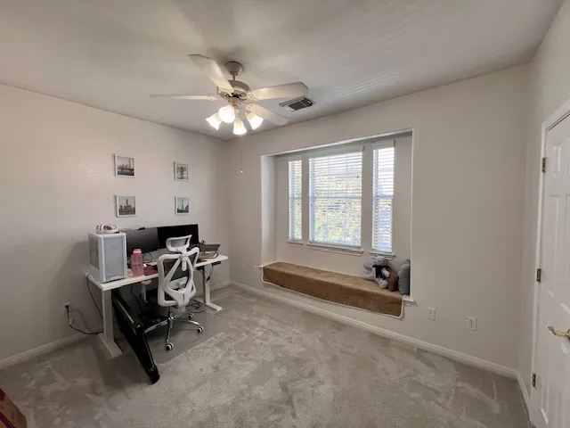 a view of a workspace with furniture and a window