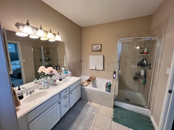 a bathroom with a sink vanity tub and shower