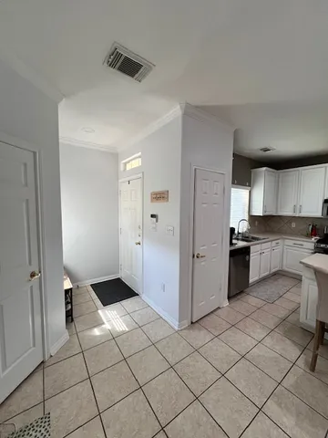 a view of a kitchen with refrigerator and white cabinets