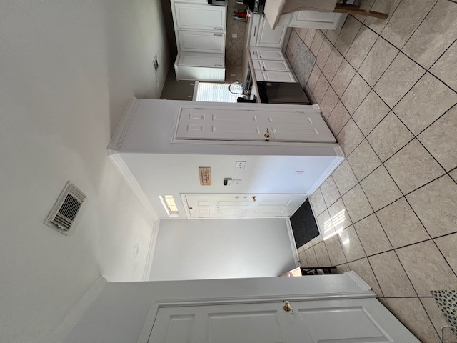 1101 East Parmer Lane, Unit 306 Austin, TX 78753 - Photo 6 of 30 a view of a kitchen with refrigerator and white cabinets