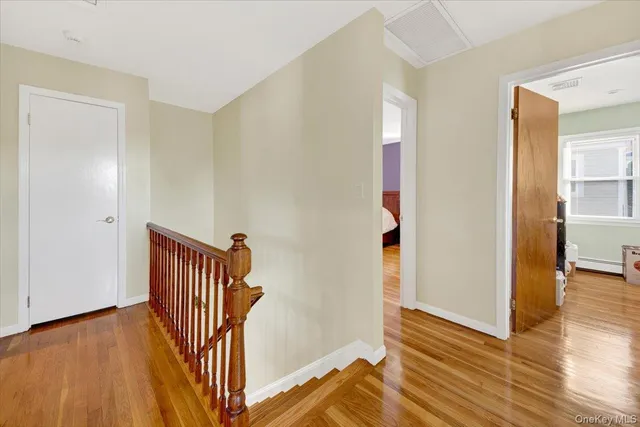 a view of a hallway with wooden floor and stairs
