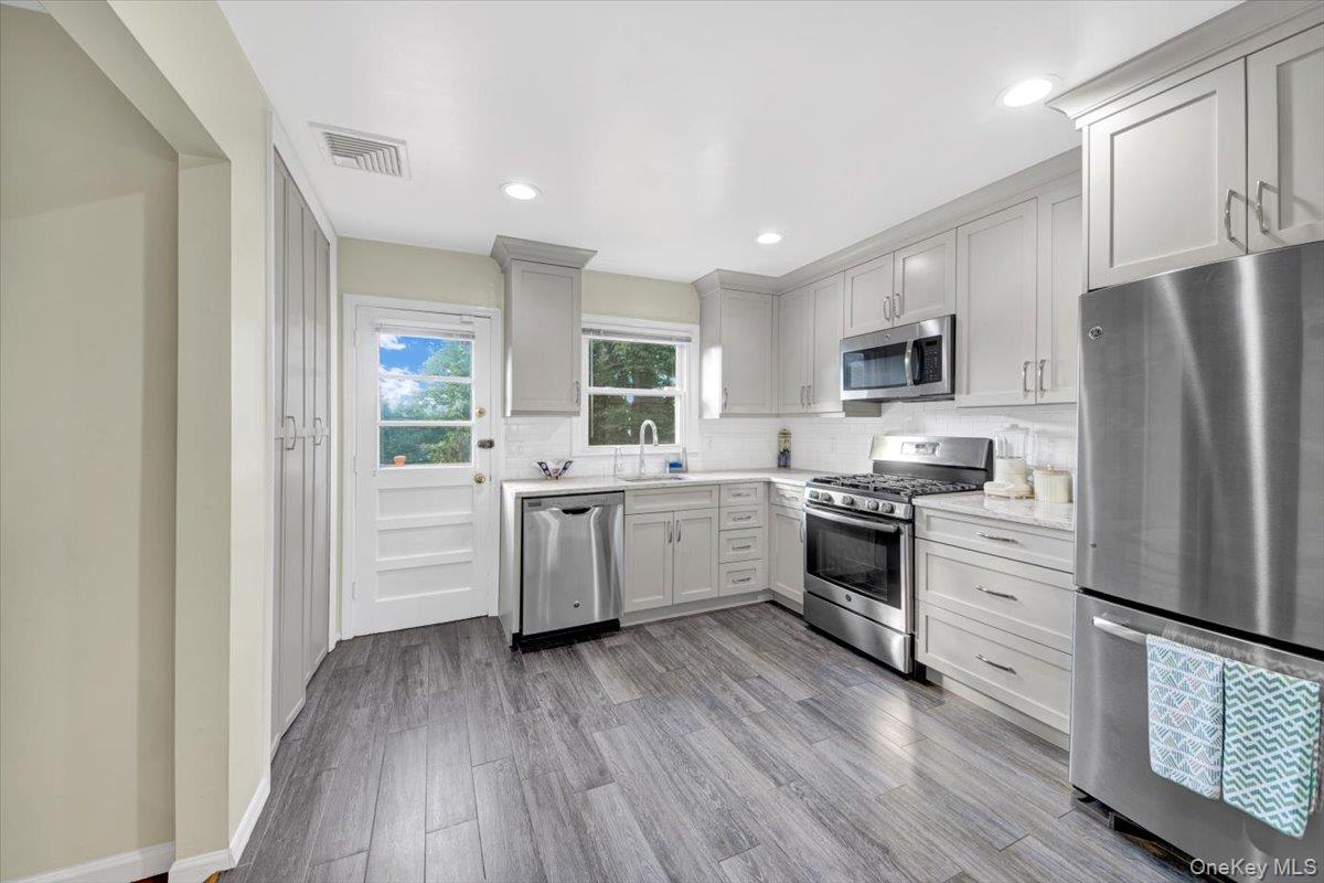39 Deshon Avenue Bronxville, NY 10708 - Photo 3 of 30 a kitchen with a refrigerator a stove top oven a sink dishwasher and wooden floor