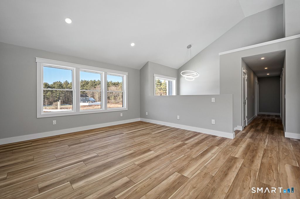 121 New Road Thompson, CT 06277 - Photo 13 of 40 an empty room with wooden floor and windows
