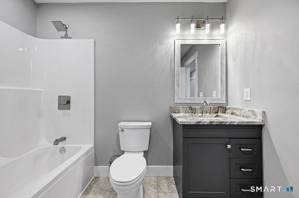 121 New Road Thompson, CT 06277 - Photo 27 of 40 a bathroom with a toilet a sink a tub and mirror