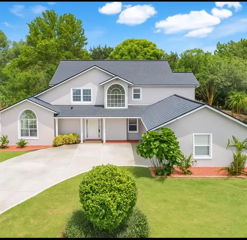 a front view of a house with a garden and yard