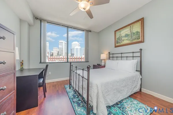 a bedroom with a bed a chandelier and windows