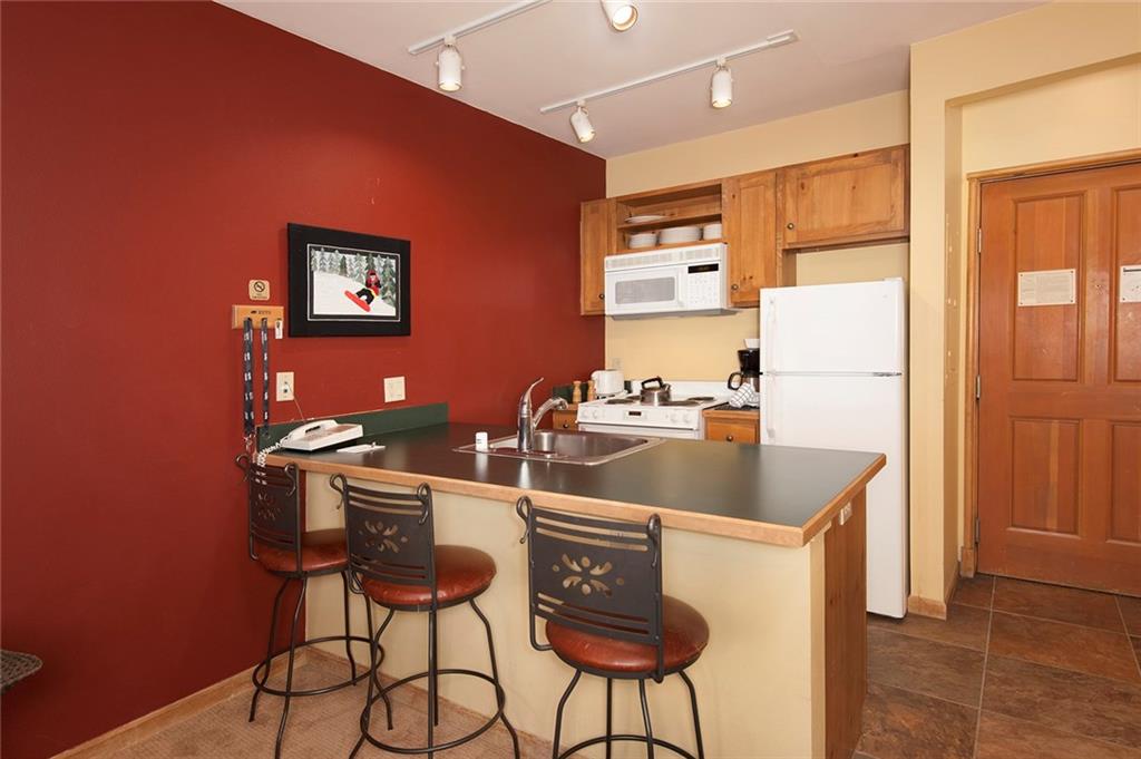 129 River Run Road, Unit 8063 Keystone, CO 80435 - Photo 13 of 23 a kitchen with a sink a refrigerator and chairs
