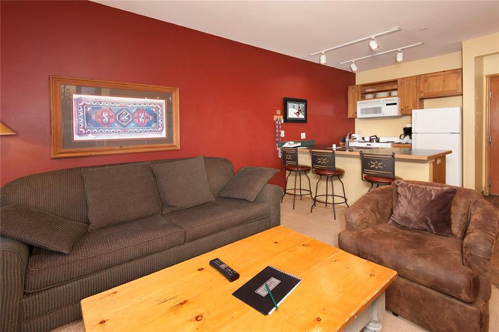 129 River Run Road, Unit 8063 Keystone, CO 80435 - Photo 4 of 23 a living room with furniture a dining table and kitchen view