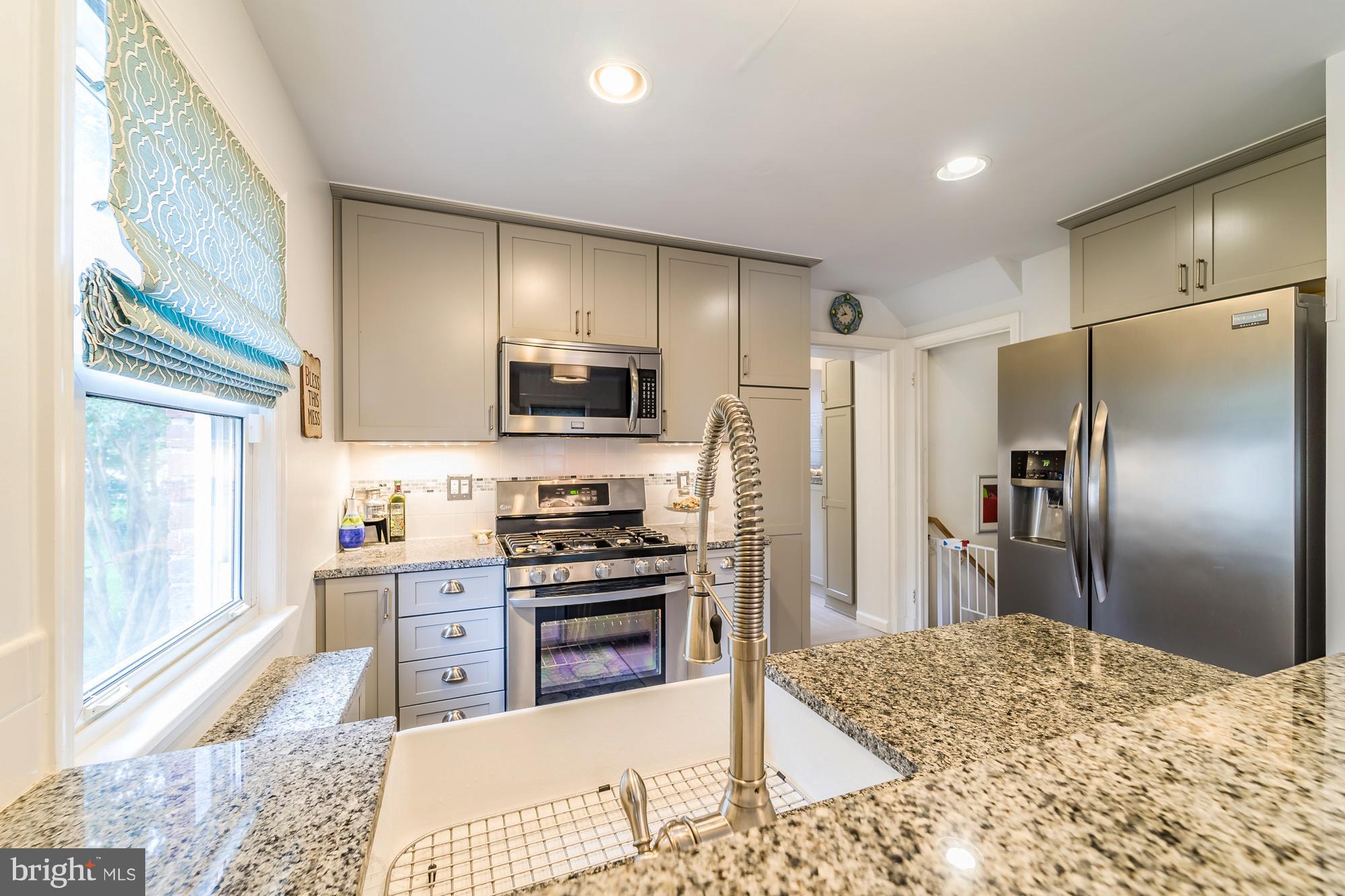 1603 Moffet Road Silver Spring, MD 20903 - Photo 10 of 30 a kitchen with stainless steel appliances kitchen island granite countertop a refrigerator stove and sink