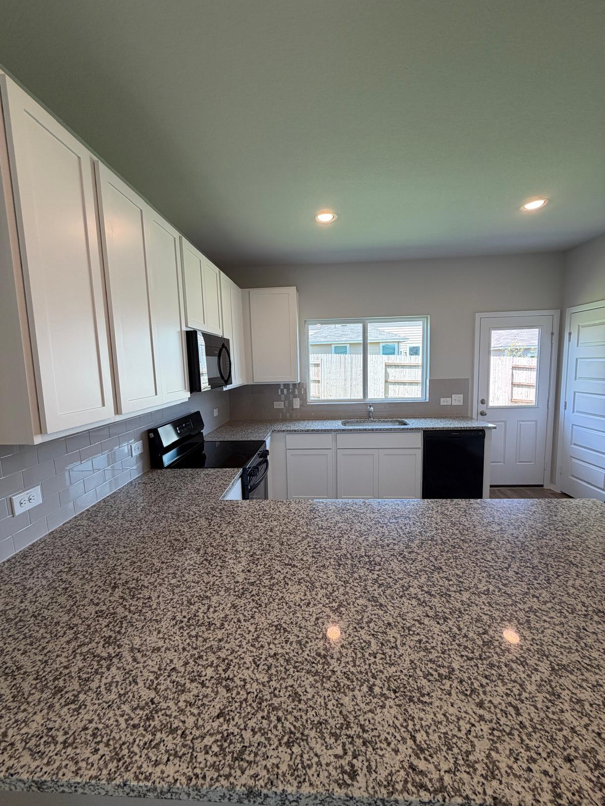2612 Towy Road Manor, TX 78653 - Photo 27 of 35 A well-appointed kitchen features ample counter space, modern appliances, and convenient outdoor access.
