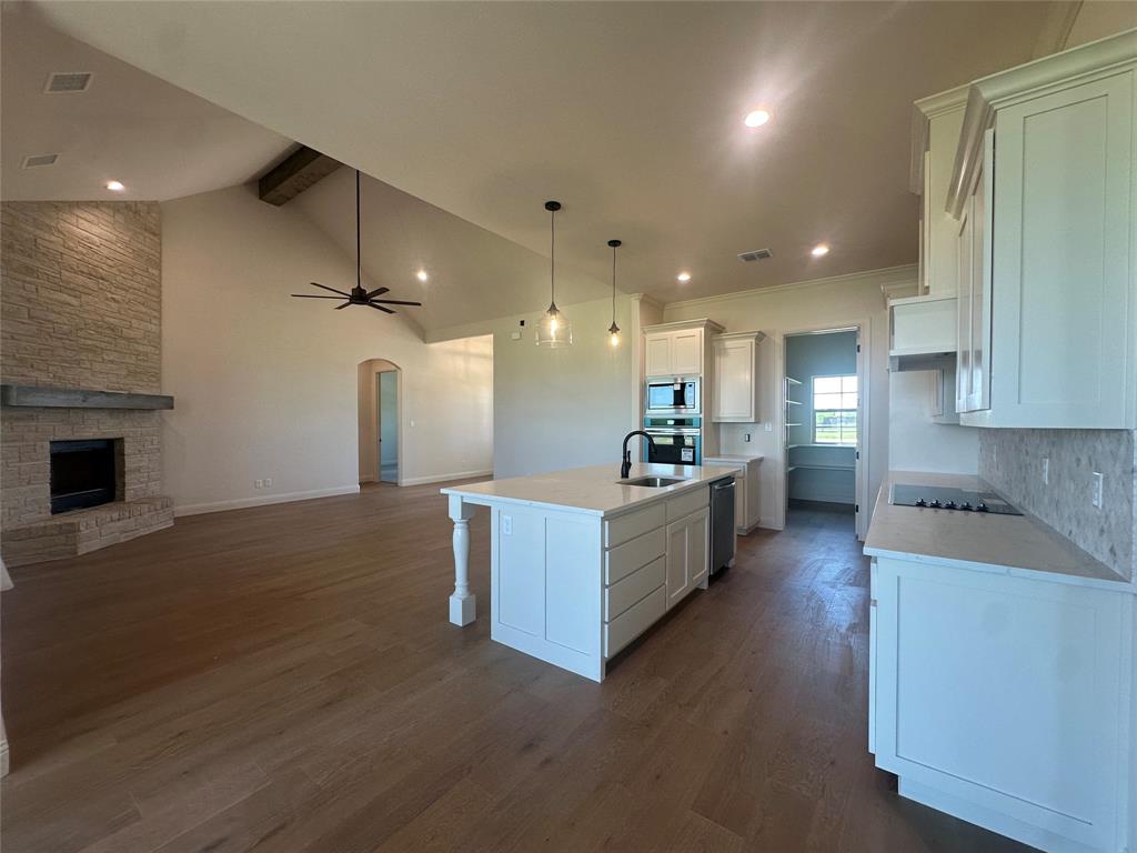 9424 Bluestem Lane DISH, TX 76247 - Photo 18 of 28 a large kitchen with stainless steel appliances kitchen island a large counter top and a wooden floors