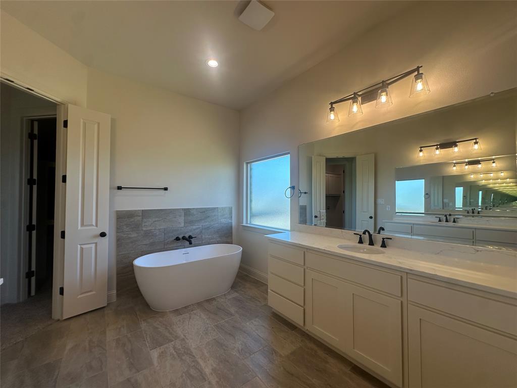 9424 Bluestem Lane DISH, TX 76247 - Photo 27 of 28 a spacious bathroom with a double vanity sink mirror and bathtub