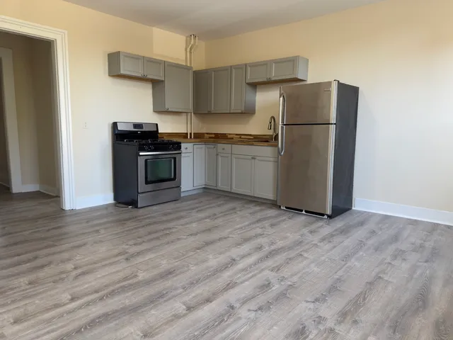 a kitchen with a refrigerator and a stove top oven