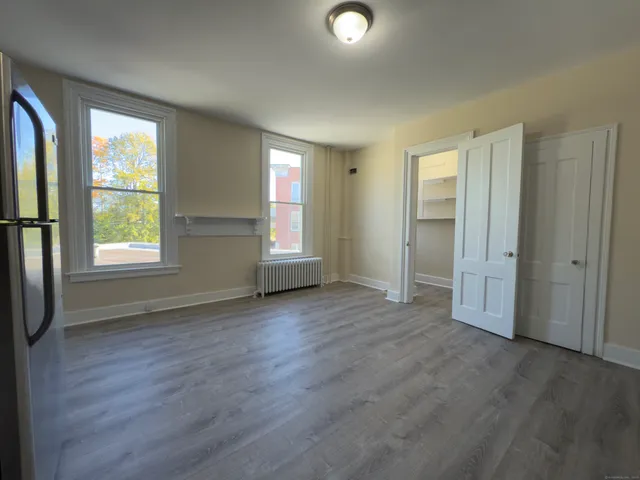 an empty room with windows and closet