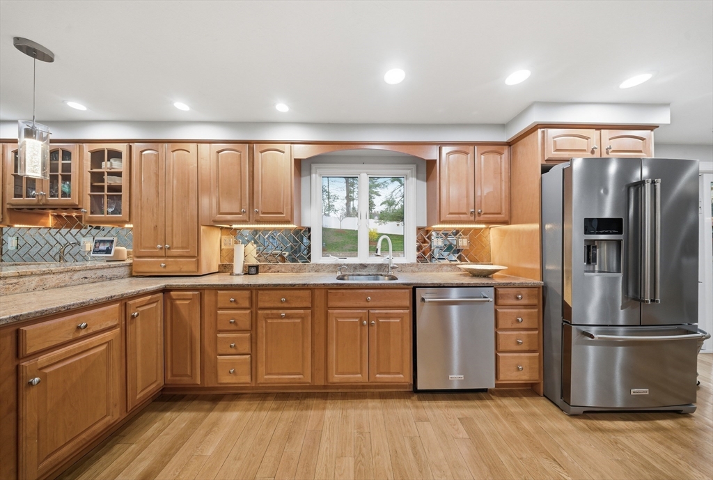 329 Orchard Street Millis, MA 02054 - Photo 2 of 42 a kitchen with stainless steel appliances granite countertop a stove a sink dishwasher a refrigerator and white cabinets with wooden floor