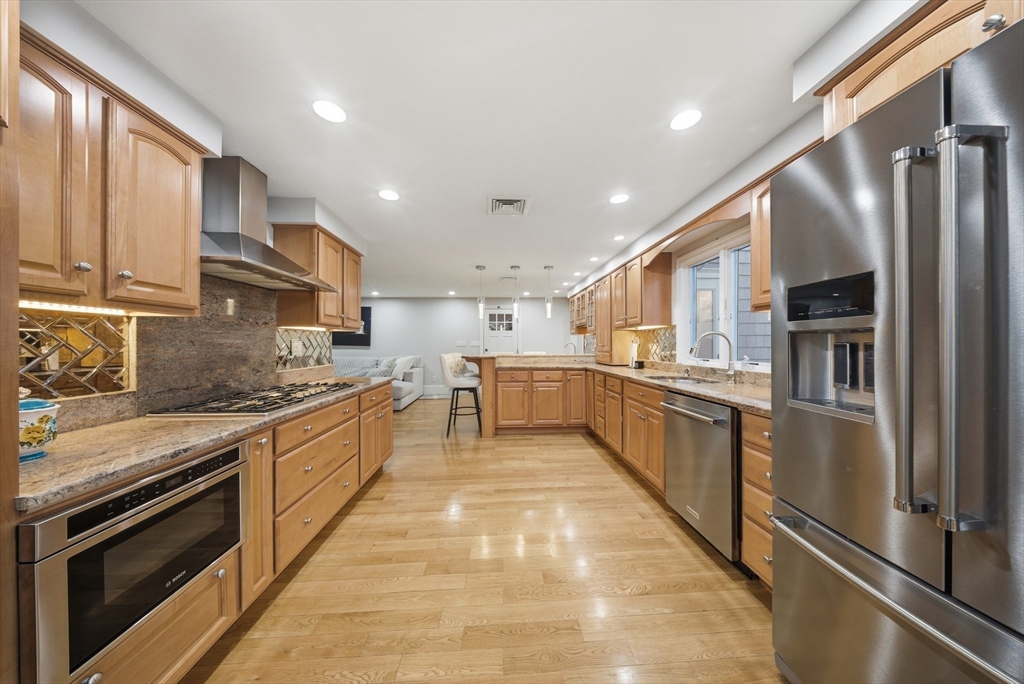 329 Orchard Street Millis, MA 02054 - Photo 3 of 42 a large kitchen with stainless steel appliances granite countertop a large counter top a stove and a refrigerator