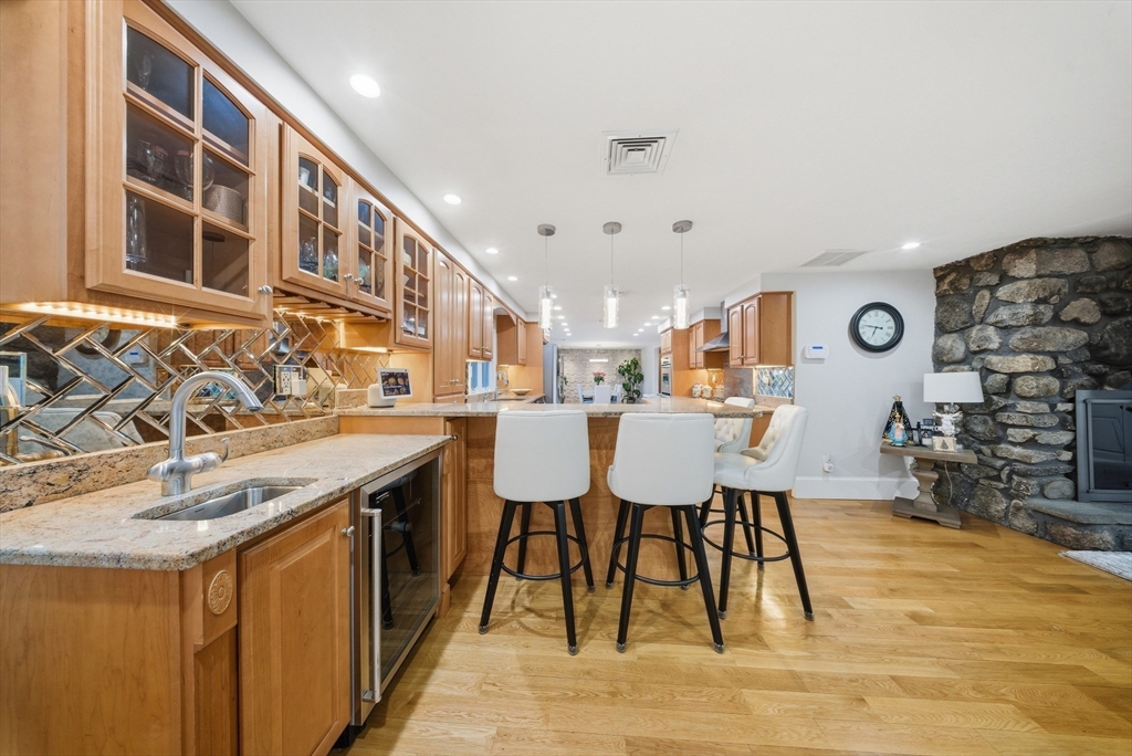 329 Orchard Street Millis, MA 02054 - Photo 4 of 42 a dining hall with stainless steel appliances granite countertop a sink and a wooden floor