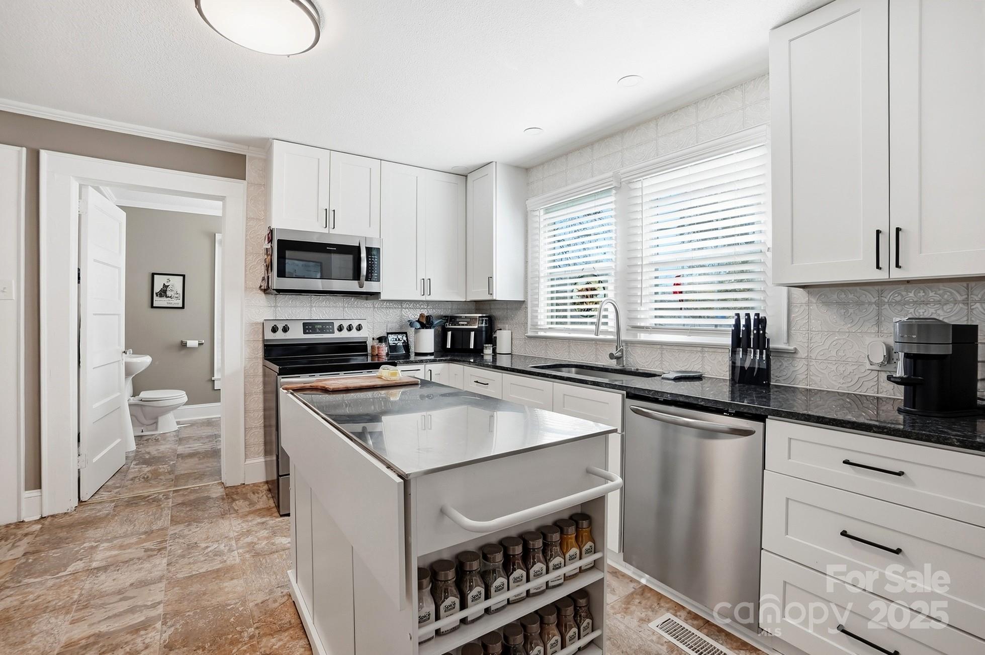 708 Mable Avenue Kannapolis, NC 28083 - Photo 13 of 48 a kitchen with granite countertop a sink stainless steel appliances and cabinets