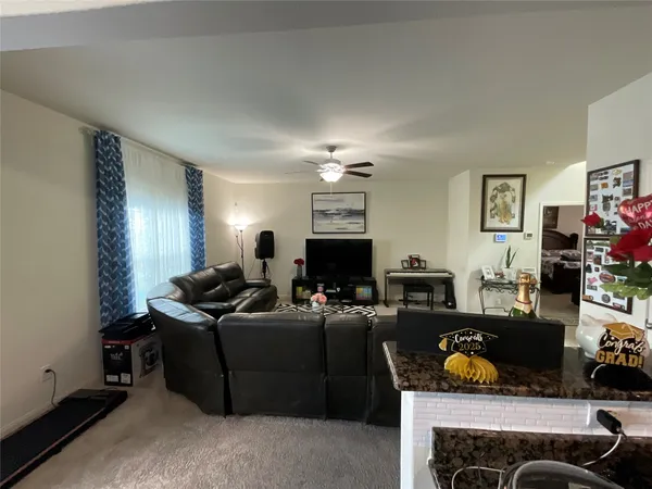a living room with furniture a fireplace and a chandelier