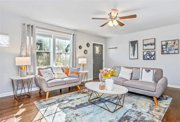 a living room with furniture a table and a large window