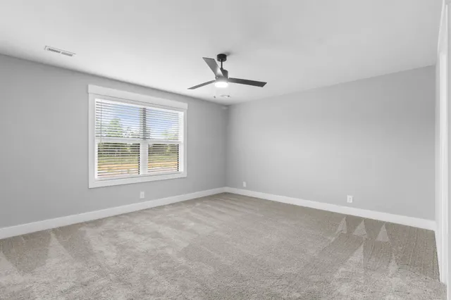 an empty room with a window and a ceiling fan