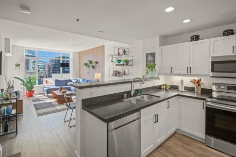 a kitchen with granite countertop a stove sink and cabinets