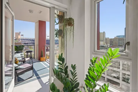 a view of a balcony with potted plants and floor to ceiling window