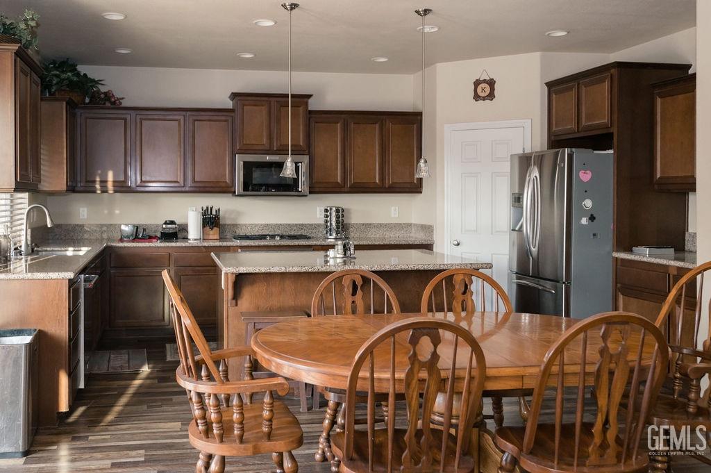 Undisclosed Address Bakersfield, CA 93314 - Photo 14 of 54 a kitchen with stainless steel appliances granite countertop a dining table and chairs