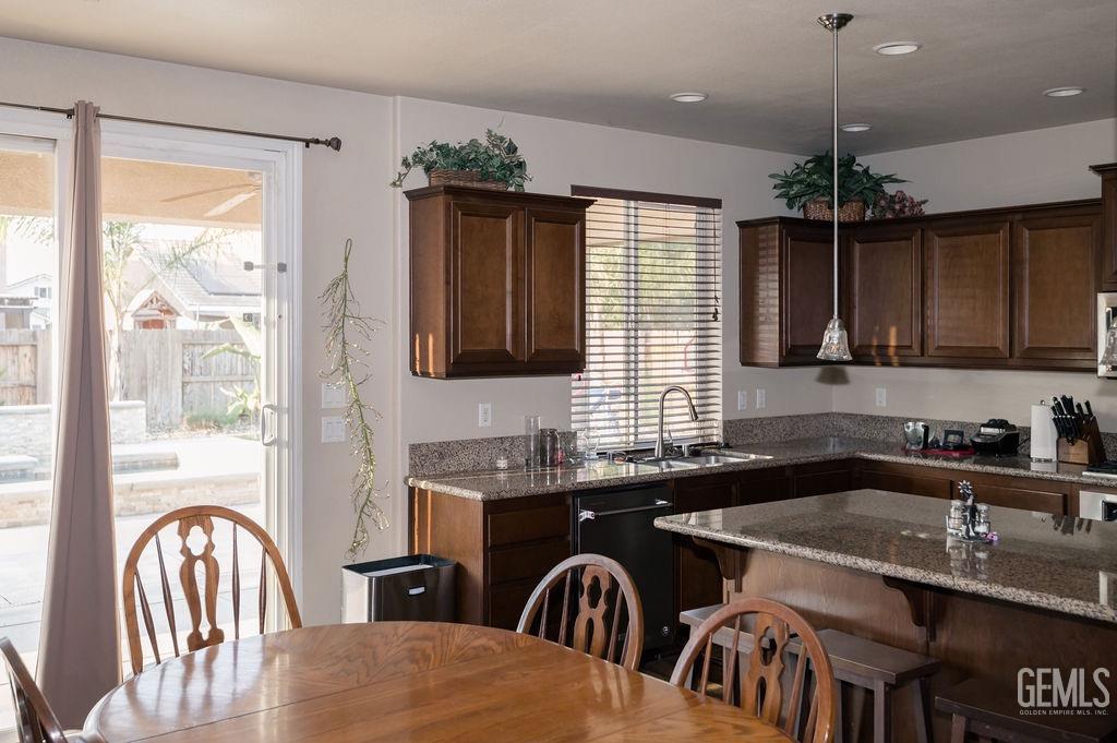 Undisclosed Address Bakersfield, CA 93314 - Photo 19 of 54 a kitchen with granite countertop a sink a stove a dining table and chairs