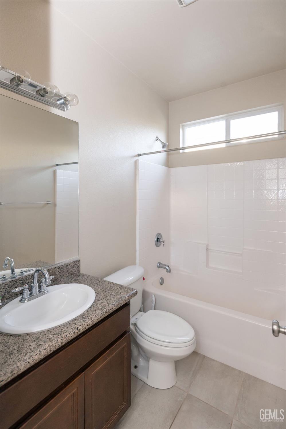 Undisclosed Address Bakersfield, CA 93314 - Photo 31 of 54 a bathroom with a granite countertop sink a toilet a mirror and shower
