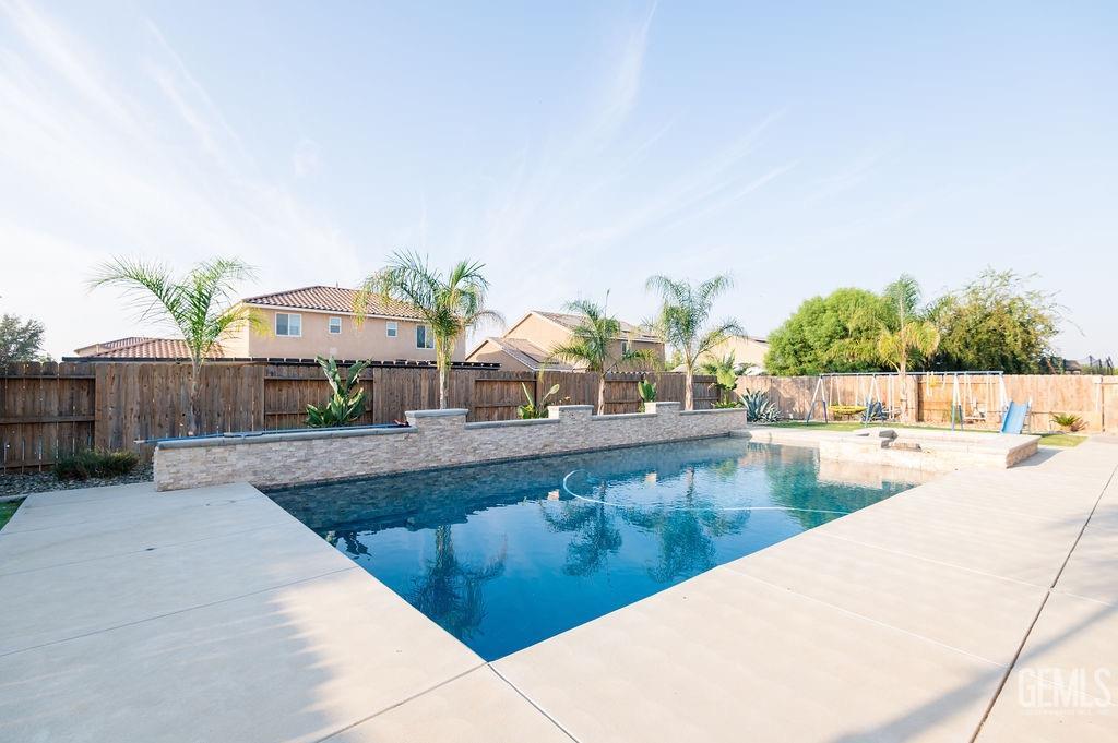 Undisclosed Address Bakersfield, CA 93314 - Photo 40 of 54 a view of a swimming pool with a lounge chair