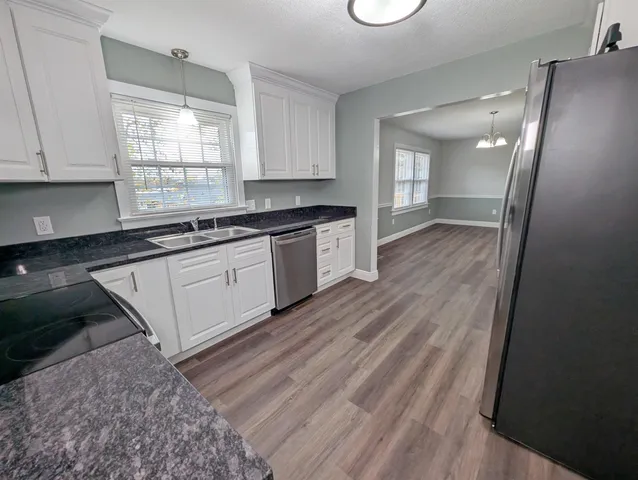 a large kitchen with stainless steel appliances granite countertop a stove a sink and a refrigerator