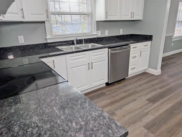a kitchen with granite countertop a sink and cabinets