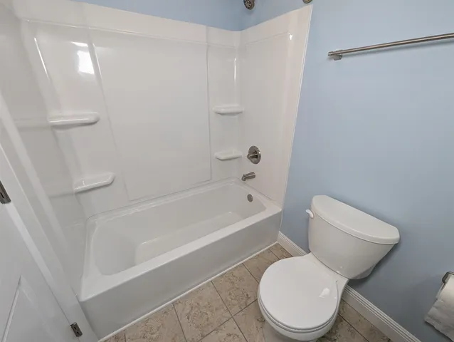 a white toilet and tub sitting next to a shower