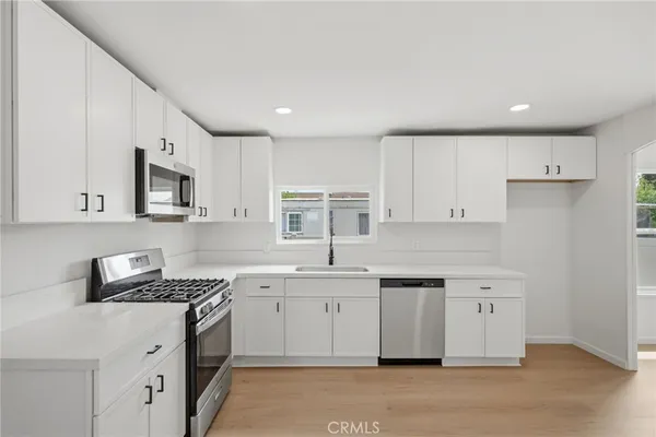 a kitchen with a sink stove top oven and cabinets