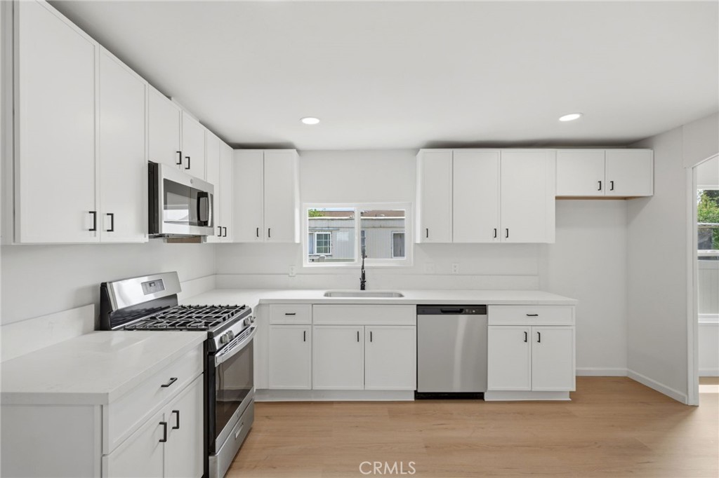 33098 Finch Street Winchester, CA 92596 - Photo 13 of 36 a kitchen with a sink stove top oven and cabinets