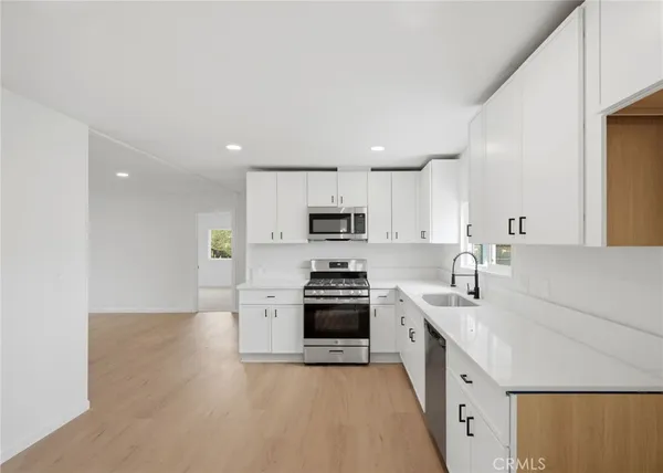 a kitchen with stainless steel appliances white cabinets and a sink