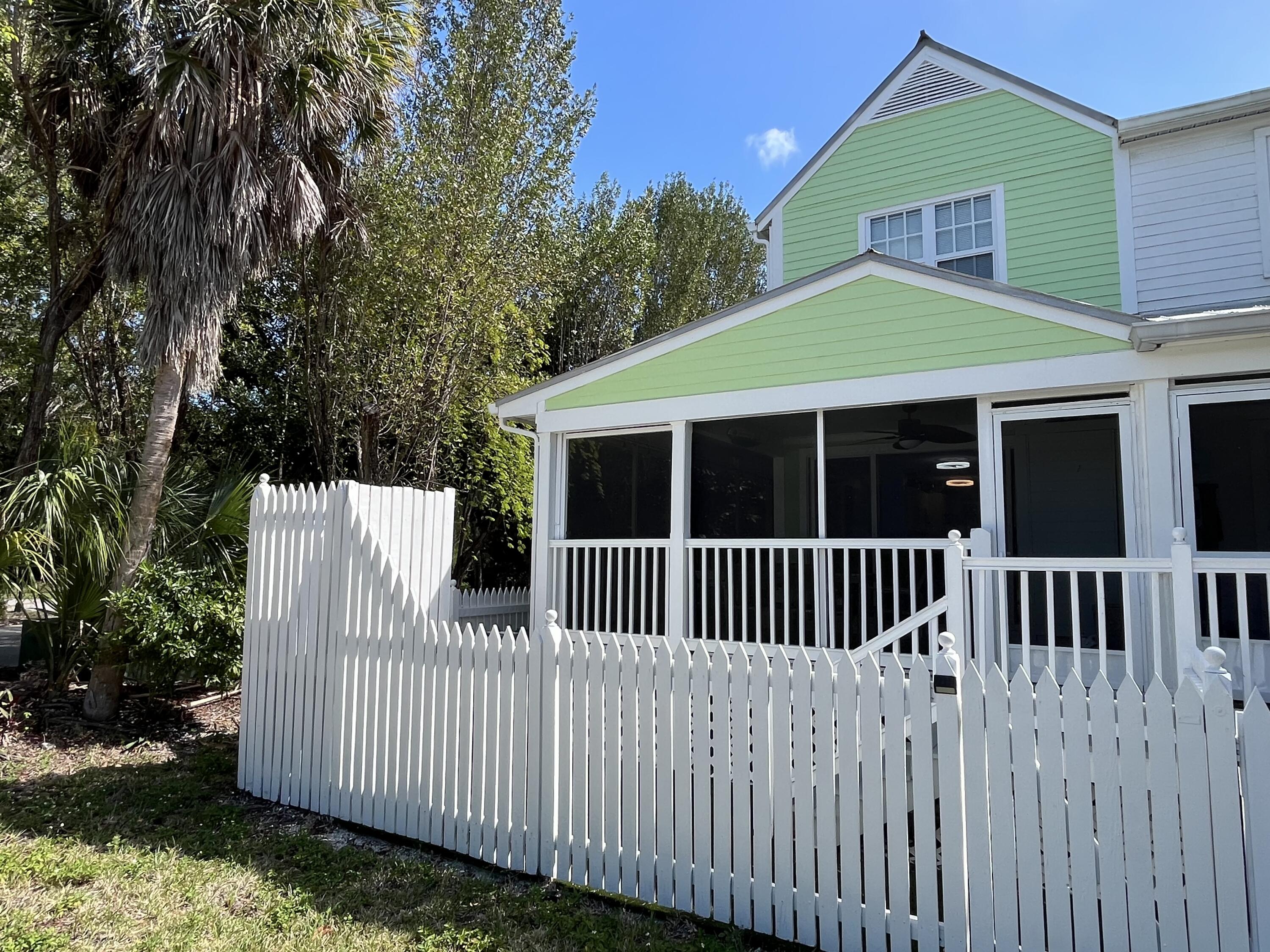 68 Merganser Lane Key West, FL 33040 - Photo 14 of 21 a view of a white house with a small yard and large trees