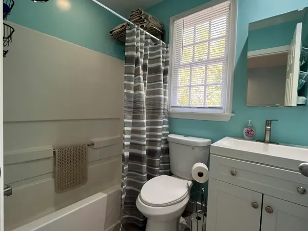 a bedroom with a bed and a flat tv screen on dresser