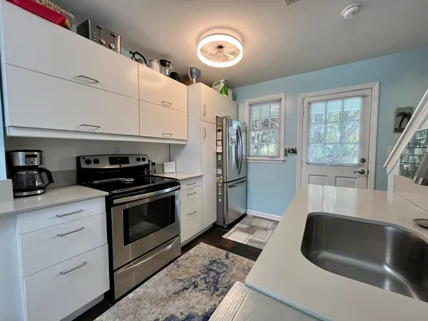 a kitchen with granite countertop a sink stainless steel appliances and cabinets