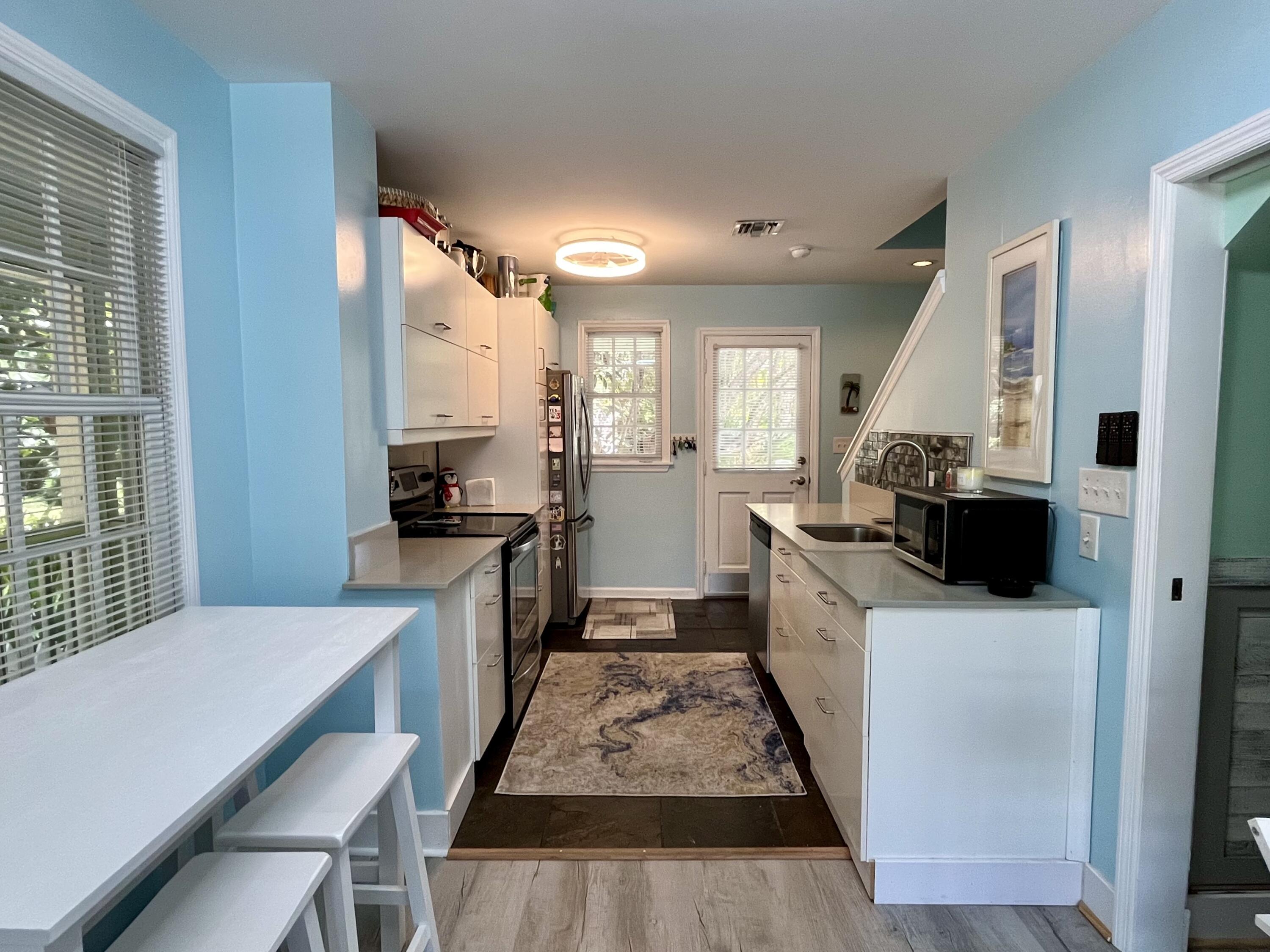 68 Merganser Lane Key West, FL 33040 - Photo 9 of 21 a kitchen with a sink a counter top space stainless steel appliances and a window