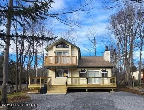 a view of a house with wooden deck front of house