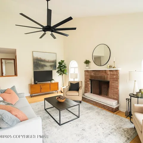 a view of a room with wooden floor and a ceiling fan